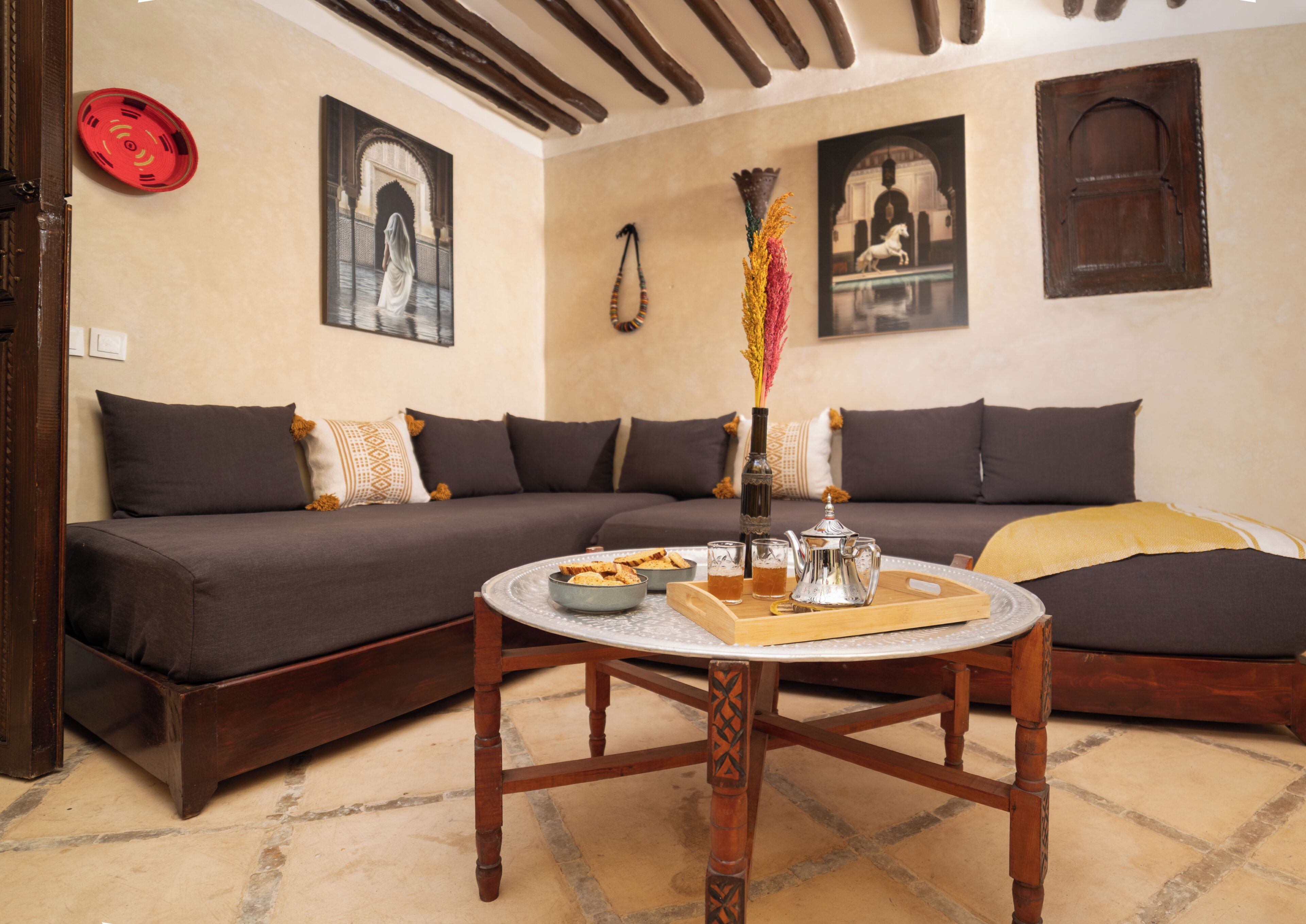 A cozy living room with a sofa, a coffee table with a tray of snacks, and decorative items.