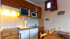 Ett kök med träskåp, en mikrovågsugn, en kaffebryggare och en diskmaskin.