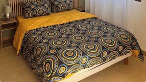 A bedroom with a bed, a nightstand, a lamp, and a window with curtains. - On the wine route and Christmas markets (Beblenheim)