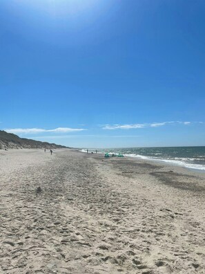 A wide sandy beach with footprints, a few tents, and a clear blue sky. - Charming west coast house near Vedersø Klit Strand (Ulfborg)