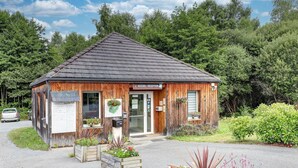 A wooden building with a sign reading 'ACCUEIL / RECEPTION' and a small entrance. - Cosy Apartment Near Egletons Town (Egletons)