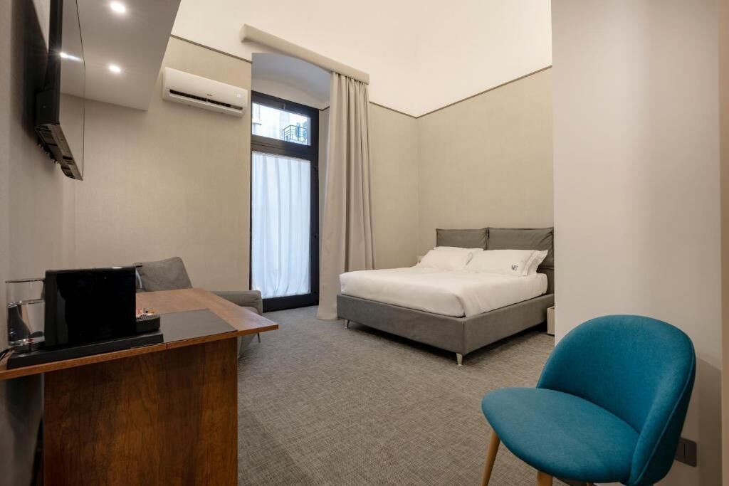Une chambre d’hôtel équipée d’un lit, d’un bureau, d’une chaise, d’une télévision et d’un appareil de climatisation.