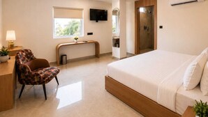 Una habitación de hotel moderna con cama, escritorio, silla, televisión y ventilador de techo.