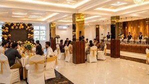 Un evento formal con mesas redondas, sillas blancas y una decoración floral central.