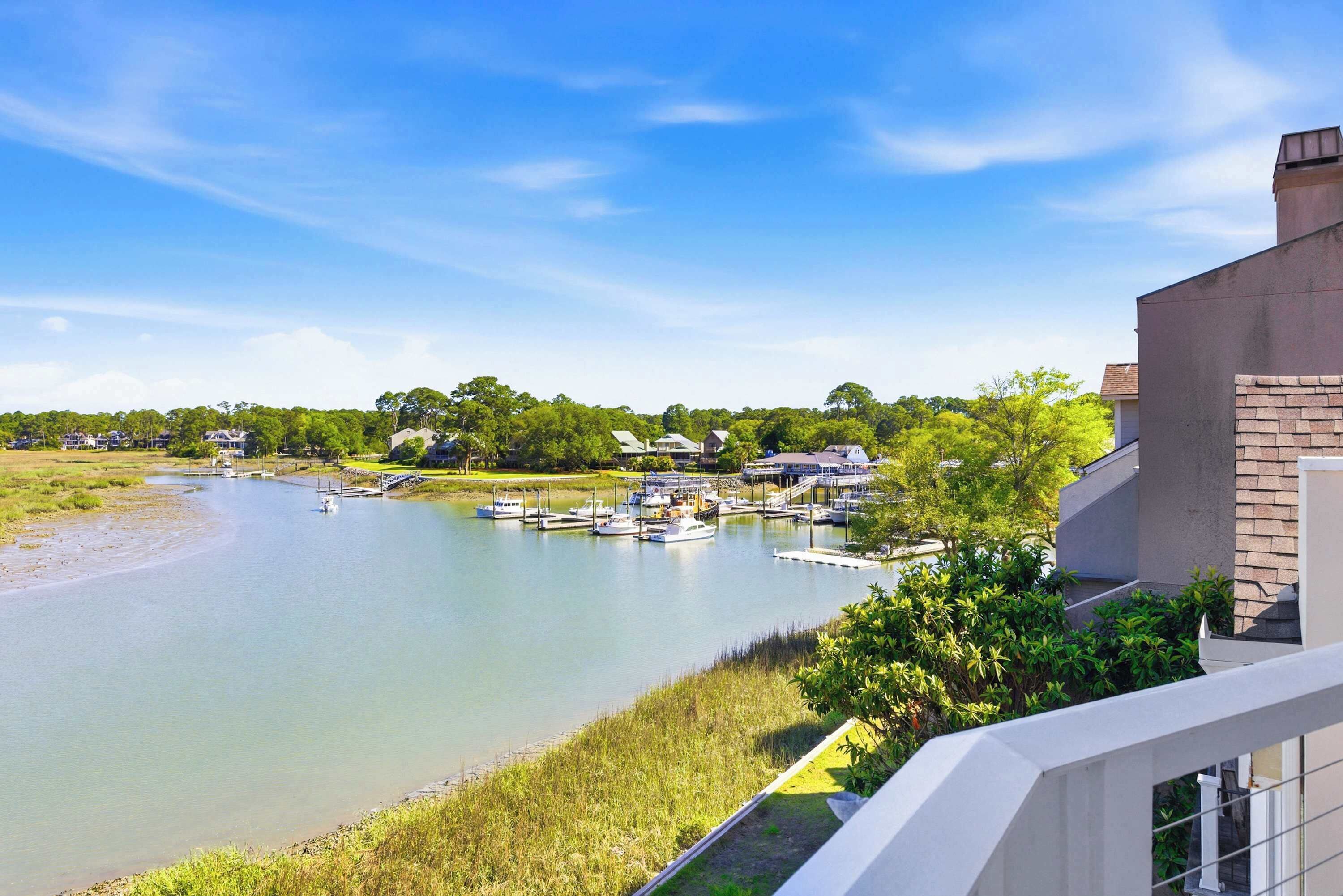 A river with boats, a dock, and houses in the background.