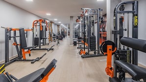 Ett gym med olika träningsmaskiner, bänkar och vikter.