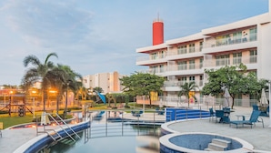 Ett hotell med en swimmingpool, utomhusplats och ett rött torn.