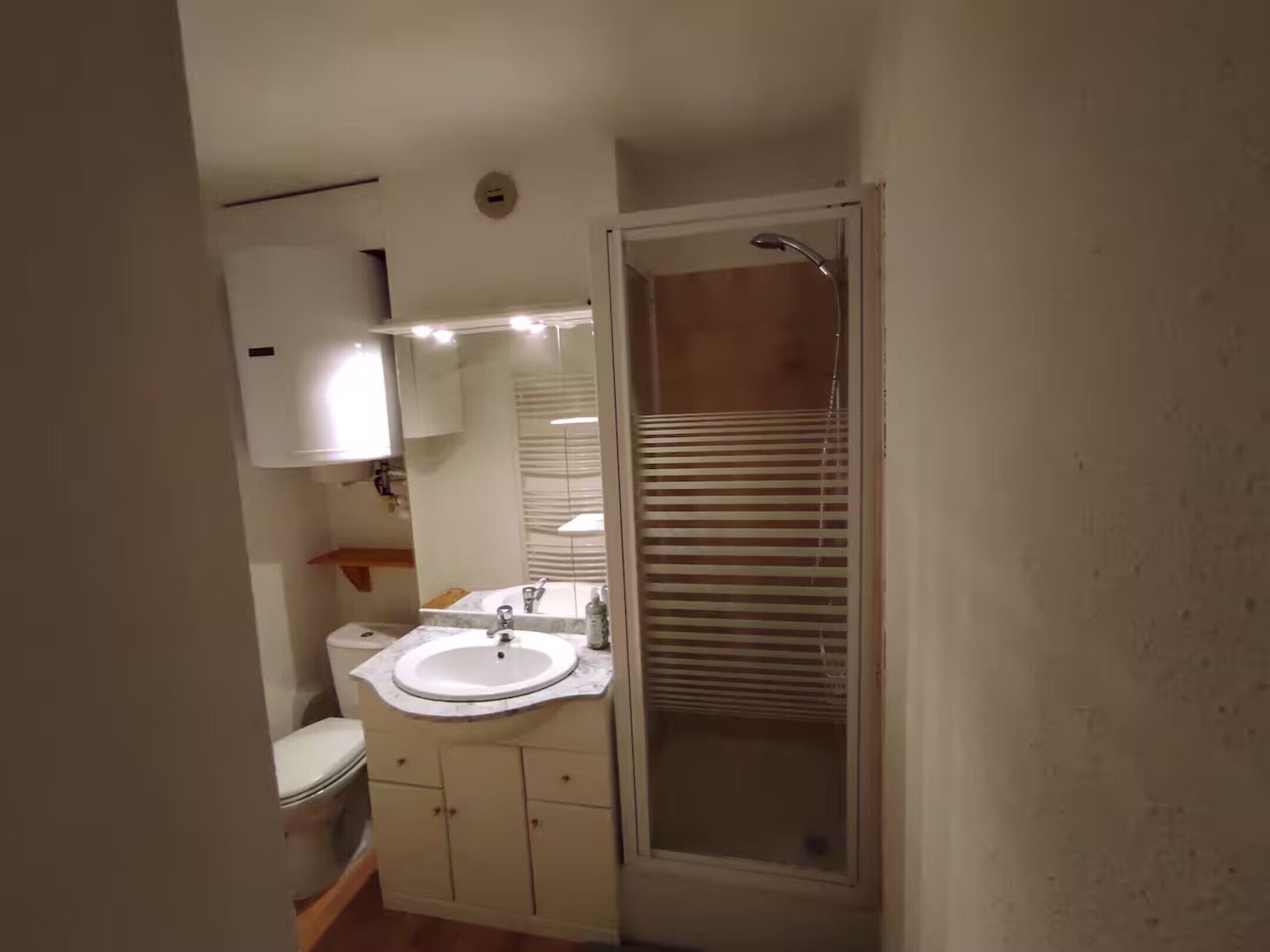 A bathroom with a toilet, sink, and shower.