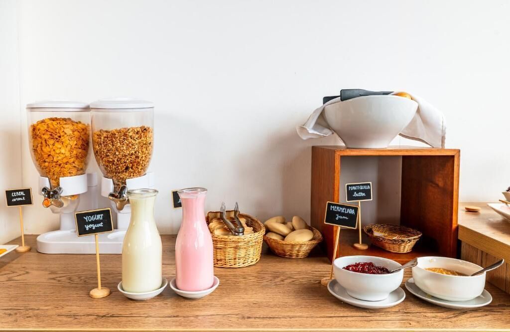 Un buffet de petit-déjeuner proposant des céréales, des yaourts et un assortiment de pains et de viennoiseries.