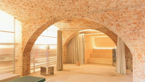 A room with a brick ceiling, a large window, a shower, and a bed. - Renovated commandery on the Elbe with sauna (Werben)