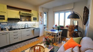 Eine moderne Küche mit Essbereich, einer Couch und einem Tisch mit Lampe.