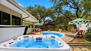 A backyard with a swimming pool, hot tubs, outdoor furniture, and a covered patio area. - Honky Tonk Dreams | Pool - Hot Tub - Games (San Antonio)