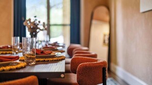 A dining table set with glasses, plates, and cutlery, with a view of the outdoors through a window. - Honky Tonk Dreams | Pool - Hot Tub - Games (San Antonio)