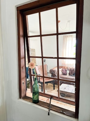 A window with a view of a room containing a sofa, a chair, and a table. - Rustic beauty in Thy's dramatic nature (Thisted)