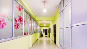 A hallway with lockers, a ceiling light, and a door at the end. - Classic With Balcony Yug Residency (Varanasi)