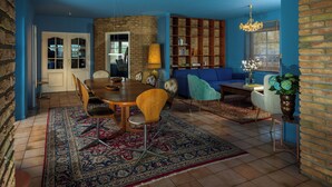 A dining area with a wooden table, chairs, and a patterned rug. - Stylish apartment Zander on the Eider river bend (Stapel)