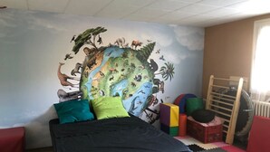 A room with a bed, a mural of animals on the wall, a window, and a radiator. - Room in house in Bourg-en-Bresse (near Brou church and Ainterexpo) (Bourg-en-Bresse)