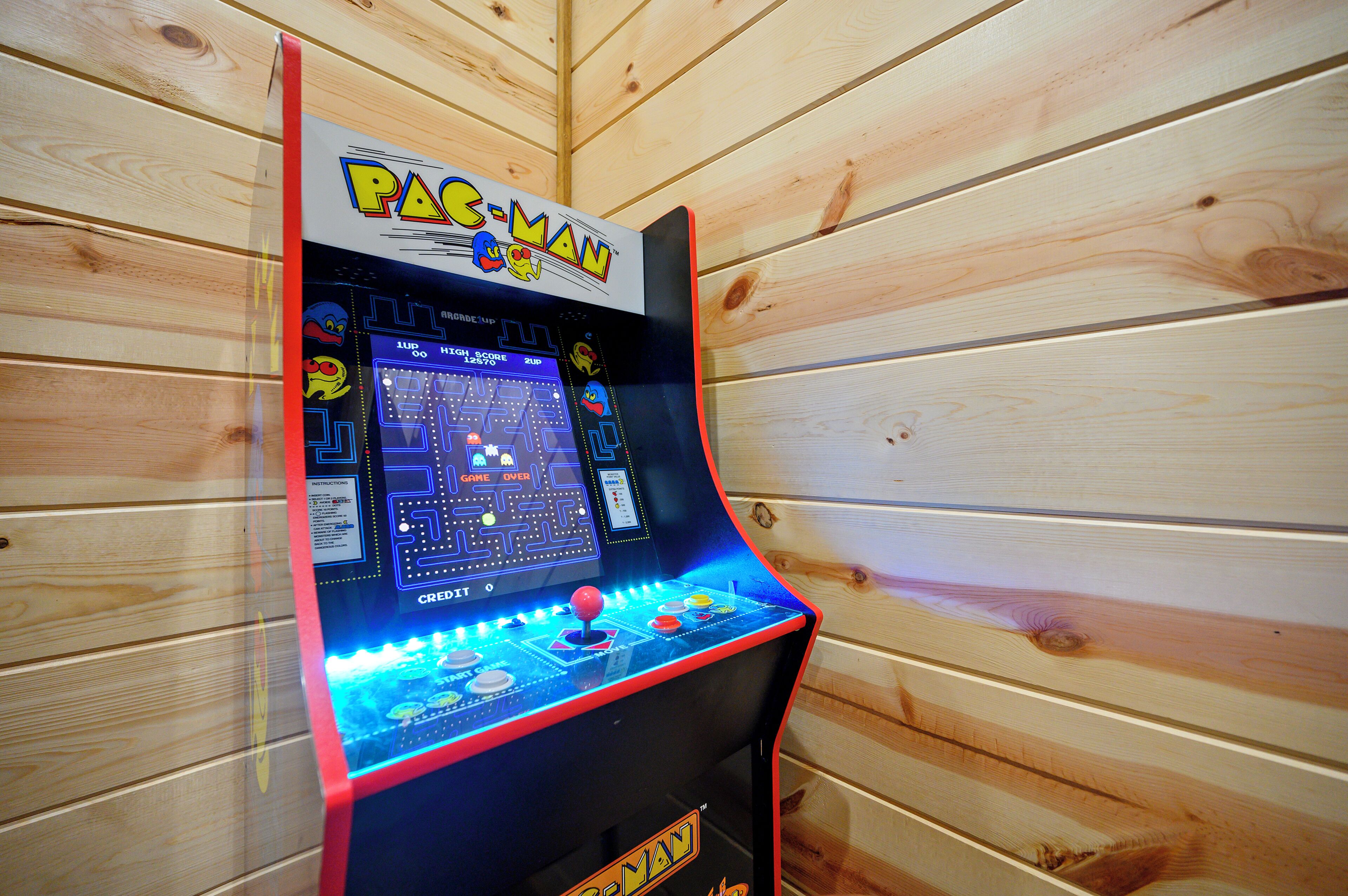 A Pac-Man arcade machine with a digital display, joystick, and score counter.