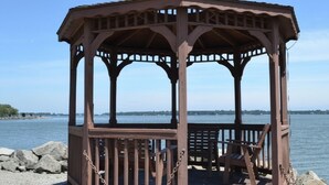 A wooden gazebo with a roof, situated by a body of water. -  Pirate Beach 2BR Villa #17 at South Beach Resort — Near Pools and splash pad (Lakeside Marblehead)