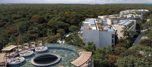 A resort with a large swimming pool, multiple hot tubs, and a view of the surrounding forest. - Spacious 3-bedrm Tulum Pent House with Private Pool & BBQ is close to everything (Tulum)