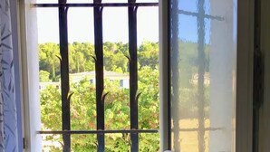 Un baño con ventana, pared de azulejos y un armario con placa.