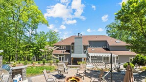 A patio with outdoor furniture, a fire pit, and a grill area.