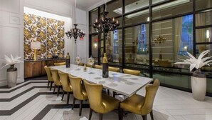 A dining area with a long table, chairs, and a chandelier. - Elegant Verdant 2BR Retreat with Gym (San Jose)