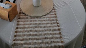 A round table with a woven placemat, a white vase with purple flowers, a framed picture, and a tissue box. - Cottage With Dock | 10 Min To  Lake Okeechobee (Okeechobee)