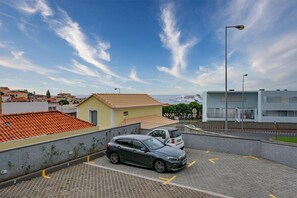 A parking area with a car, buildings in the background, and a clear sky. - Casa de Sao Tiago 2 – Funchal (Funchal)