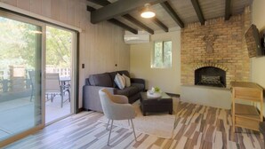 Ein Wohnzimmer mit Kamin, Sofa, Sessel und Tisch.