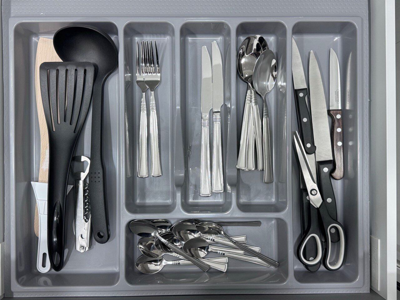 A drawer with various kitchen utensils neatly organized.