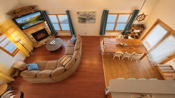 Un salon chaleureux avec une cheminée, un téléviseur, un canapé et une table à manger avec des chaises.