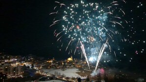 Ein Nachtblick auf eine Stadt mit einem großen Feuerwerk am Himmel.