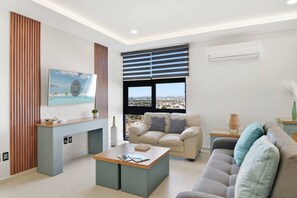 Ein stilvolles Wohnzimmer mit Sofa, Couchtisch, Fernseher und Kamin.