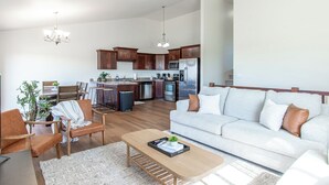 Ein modernes Wohnzimmer mit Sofa, Couchtisch und Essbereich mit Stühlen und Tisch.