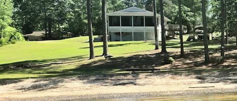 A lakeside property with a covered pavilion, a grassy area, and a dock.