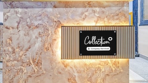 A reception desk with a marble-like surface and a sign that reads 'Collection Company-Serviced'. - Premium Hotel Maharana Pratap (Ujjain)
