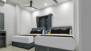 A room with two beds, a ceiling fan, an air conditioning unit, and a window with curtains. - Premium Hotel Maharana Pratap (Ujjain)