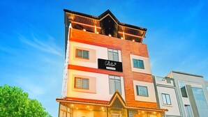 A multi-story building with a prominent sign, a staircase leading to the entrance, and a well-lit facade. - Premium Hotel Maharana Pratap (Ujjain)
