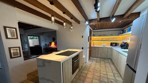 Una cucina moderna con isola centrale, forno integrato e pavimento in piastrelle di pietra.