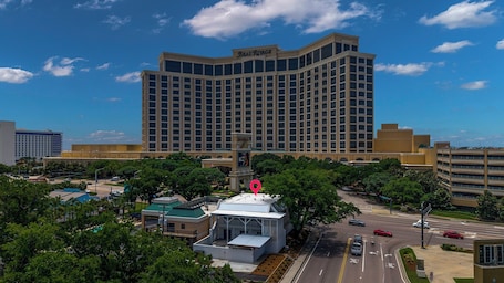 A large hotel with a prominent 'Beau Rivage' sign, surrounded by greenery and a parking structure.. Hotel Biloxi