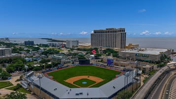 A baseball stadium with a large field, surrounding buildings, and a view of the water.