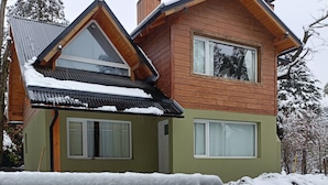 A wooden house with a green facade and a sloped roof, surrounded by snow. - Between Lakes and Mountains • Your Place in Bariloche (San Carlos de Bariloche)