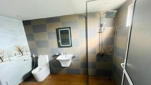 A bathroom with a toilet, sink, and shower.