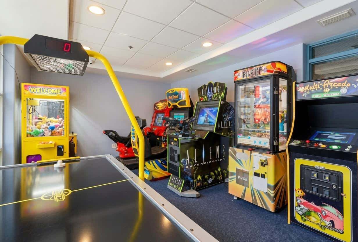 Eine Indoor-Spielhalle mit verschiedenen Spielautomaten, darunter ein Tischtennistisch und Krabschere-Greifautomaten.