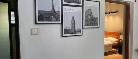 A hallway with framed cityscape posters of Paris, London, and Rome.