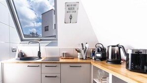 A modern kitchen with a skylight, a coffee maker, and a kettle on the counter. - Central vacation apartment in Arnsberg's old town (Arnsberg)