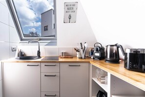 Eine moderne Küche mit Oberlicht, einer Kaffeemaschine und einem Wasserkocher auf der Arbeitsfläche.