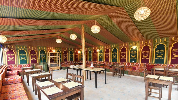 Ein traditionelles Gasthaus mit Holzmöbeln, gemusterten Wänden und hängenden Laternen.