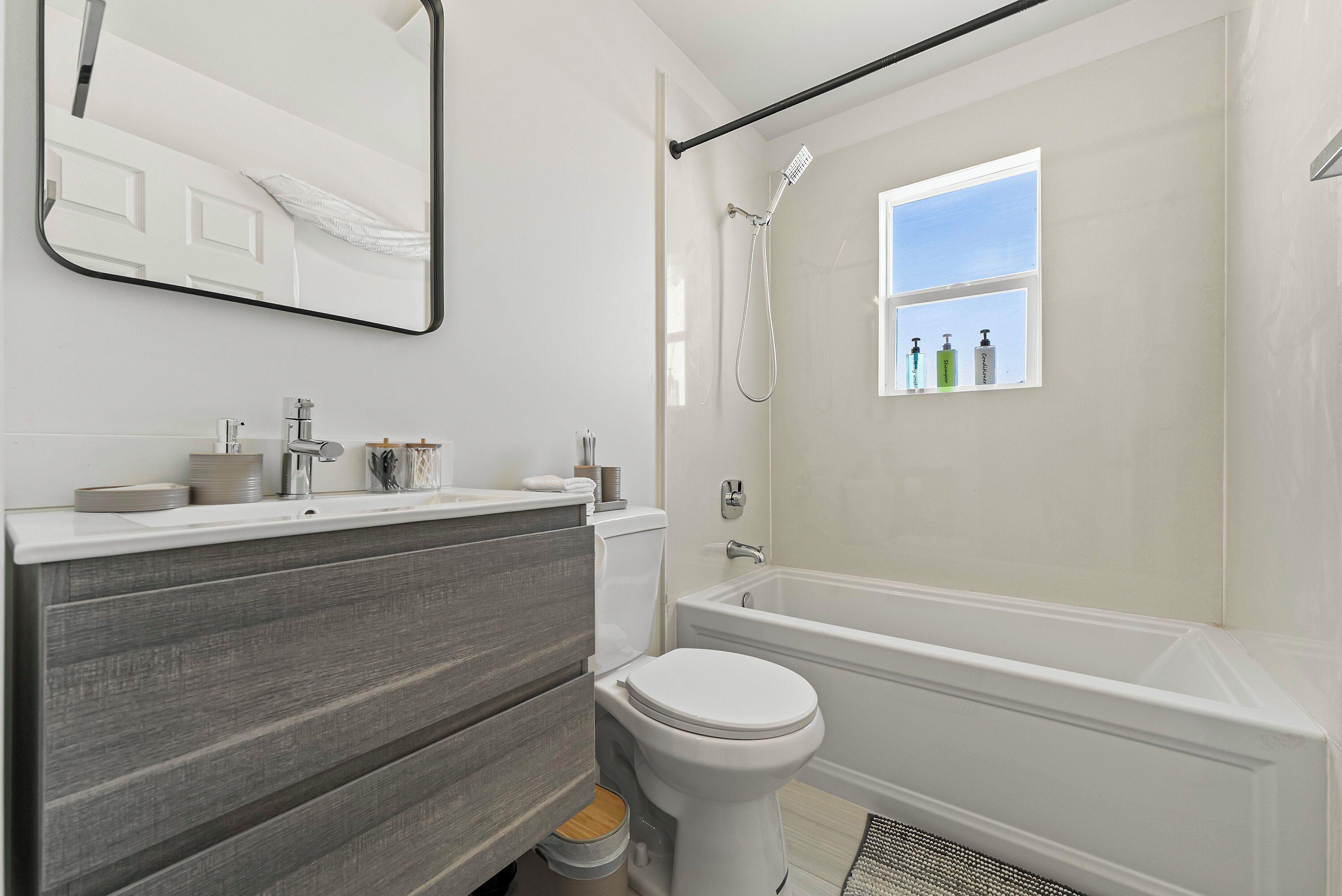 Un baño moderno con inodoro, tocador y bañera.